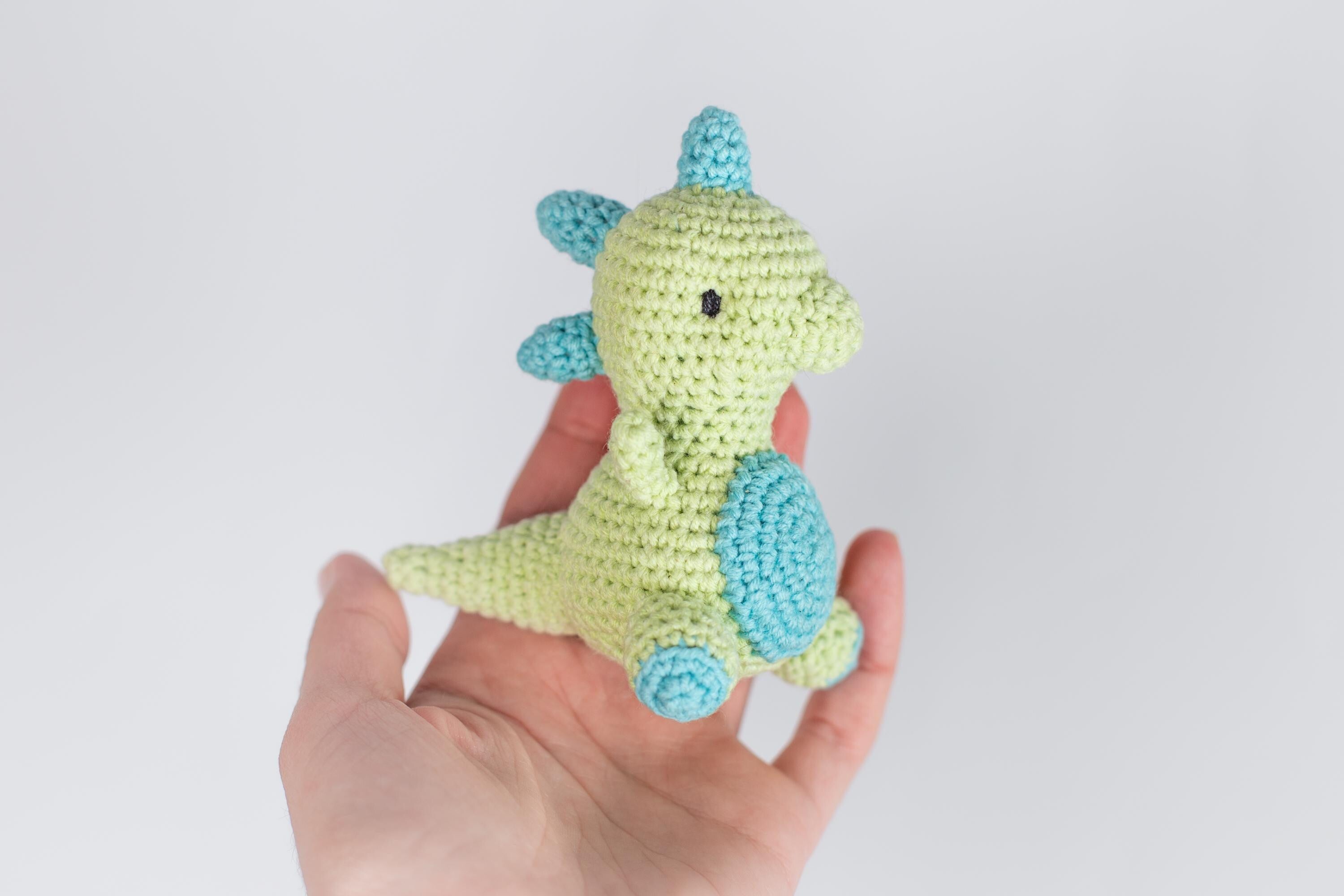 a hand holding a small crocheted toy in it's palm